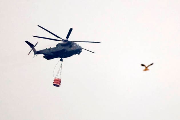 Hubschrauber von Bundeswehr und Bundespolizei, Bergepanzer der Bundeswehr und zahlreiche Kräfte von Feuerwehr und anderen Freiwilligen sind beim Waldbrand im Hürtgenwald im Einsatz. Mehrere Hundert Hektar Waldfläche stehen in Flammen, die Feuerwalze hat sich bis dicht an einzelne Stadtteile herangefressen. Bauern und Helfer bringen immer wieder neue Wassertanks heran. Wegen der anhaltenden Hitzewelle sind die Wälter extrem trocken. Hürtgenwald, 15.08.2026 NRW Deutschland *** Helicopters from the German Armed Forces and the Federal Police, armored recovery vehicles from the German Armed Forces, and numerous firefighters and other volunteers are on the scene of the wildfire in the Hürtgenwald. Several hundred hectares of forest are ablaz Copyright: xChristophxHardtx