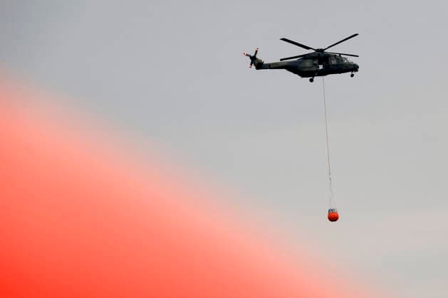 Hubschrauber von Bundeswehr und Bundespolizei, Bergepanzer der Bundeswehr und zahlreiche Kräfte von Feuerwehr, Polizei und anderen Freiwilligen sind beim Waldbrand im Hürtgenwald im Einsatz. Mehrere Hundert Hektar Waldfläche stehen in Flammen, die Feuerwalze hat sich bis dicht an einzelne Stadtteile herangefressen. Bauern und Helfer bringen immer wieder neue Wassertanks heran. Wegen der anhaltenden Hitzewelle sind die Wälter extrem trocken. Hürtgenwald, 15.08.2026 NRW Deutschland *** Helicopters from the German Armed Forces and the Federal Police, armored recovery vehicles from the German Armed Forces, and numerous firefighters, police officers, and other volunteers are on the scene of the forest fire in the Hürtgenwald. Several hundre Copyright: xChristophxHardtx