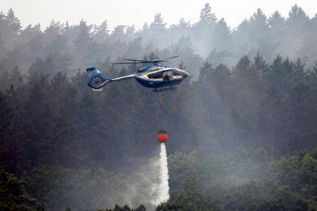 Hubschrauber von Bundeswehr und Bundespolizei, Bergepanzer der Bundeswehr und zahlreiche Kräfte von Feuerwehr, Polizei und anderen Freiwilligen sind beim Waldbrand im Hürtgenwald im Einsatz. Mehrere Hundert Hektar Waldfläche stehen in Flammen, die Feuerwalze hat sich bis dicht an einzelne Stadtteile herangefressen. Bauern und Helfer bringen immer wieder neue Wassertanks heran. Wegen der anhaltenden Hitzewelle sind die Wälter extrem trocken. Hürtgenwald, 15.08.2026 NRW Deutschland *** Helicopters from the German Armed Forces and the Federal Police, armored recovery vehicles from the German Armed Forces, and numerous firefighters, police officers, and other volunteers are on the scene of the forest fire in the Hürtgenwald. Several hundre Copyright: xChristophxHardtx