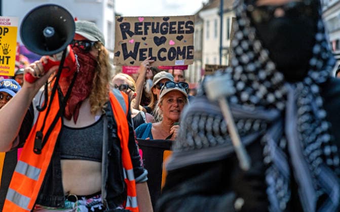 News Bilder des Tages Anti-immigration demonstrators and Stand Up to Racism counter-protesters rally in Maidstone MAIDSTONE, UNITED KINGDOM - AUGUST 15: Activists from Stand Up to Racism assemble outside County Hall in Maidstone, Kent, United Kingdom, on August 15, 2026, to counter-protest against the far-right Kent Nationalist Movement as they gathered before marching through the town center. While the far-right group voiced opposition to government border policies, asylum seeker housing programs, and mass migration, Stand Up to Racism demonstrators chanted slogans and displayed placards to denounce far-right activity and express solidarity with refugees, with police officers maintaining a presence to keep the opposing groups separated. Stuart Brock Anadolu M  Copyright: x2026xAnadoluxStuartxBrockx