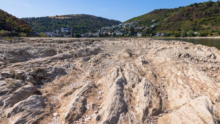 Niedrigwasser am Rhein nach langer Dürrephase, Kaub, 15.08.2026 Durch anhaltende Trockenheit ist der Flussgrund des Rheins großflächig freigelegt. Steine und Sedimente prägen das trockengefallene Flussbett bei sonnigem Wetter, im Hintergrund liegt Oberwesel am Mittelrhein am gegenüberliegenden Ufer. Kaub Rheinland-Pfalz Deutschland *** Low Water Levels on the Rhine Following a Long Drought, Kaub, August 15, 2026: Due to persistent drought, the riverbed of the Rhine has been exposed over a wide area. Rocks and sediment dominate the dry riverbed in sunny weather; in the background lies Oberwesel on the Middle Rhine on the opposite bank from Kaub, Rhineland-Palatinate, Germany 20260815-286A5715-M4000