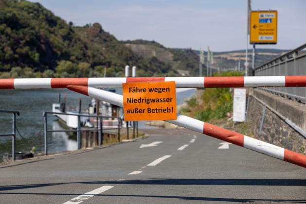 Niedrigwasser am Rhein nach langer Dürrephase, Kaub, 15.08.2026 Eine rot-weiße Schranke sperrt die Zufahrt zur Fährstelle, ein orangefarbenes Schild weist auf die Außerbetriebnahme der Fähre wegen Niedrigwasser hin. Im Hintergrund liegt ein Fährschiff am Ufer, der Wasserstand des Flusses ist deutlich abgesenkt. Kaub Rheinland-Pfalz Deutschland *** Low water levels on the Rhine following a long period of drought, Kaub, August 15, 2026 A red-and-white barrier blocks access to the ferry landing; an orange sign indicates that the ferry is out of service due to low water levels. In the background, a ferry lies at the riverbank, and the river’s water level has dropped significantly. Kaub, Rhineland-Palatinate, Germany 20260815-286A5829-M4000