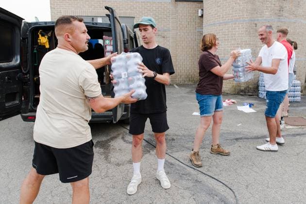 Volunteers with bottles of water as a fire rages in the Hautes Fagnes (High Fens) nature reserve, on Saturday 15 August 2026 in Waimes. The fire started on August 14th and 1600 hectares (on a total of 4500) are impacted.  NICOLASxLAMBERT 183462791