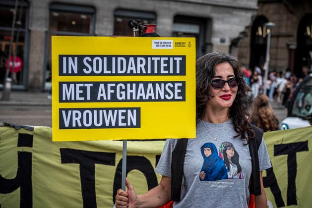 August 15, 2026, Amsterdam, North Holland, The Netherlands Holland: A demonstrator holds a sign reading Ã¢â‚¬oeIn Solidarity With Afghan WomenÃ¢â‚¬Â (translated from Dutch). August 15, 2026, Amsterdam, The Netherlands. Demonstrators gathered on Dam Square, Amsterdam, in solidarity with Afghan women and girls. The protest marked five years of Taliban rule and demanded access to education for women and girls be restored, and an end to Brussels engagement with the Taliban regime. Amsterdam The Netherlands Holland  - ZUMAp202 20260815_zip_p202_021 Copyright: xJamesxPetermeierx
