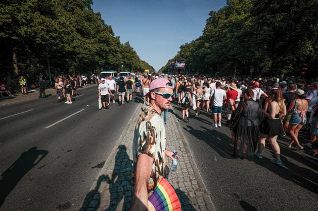 August 15, 2026, Berlin, Germany: A Rave the Planet participant dances to music while holding a fan in the colors of the LGBT flag. The event took place during a heatwave, with temperatures reaching 31 degrees Celsius. Berlin Germany - ZUMAs197 20260815_aab_s197_024 Copyright: xVasilyxKrestyaninovx