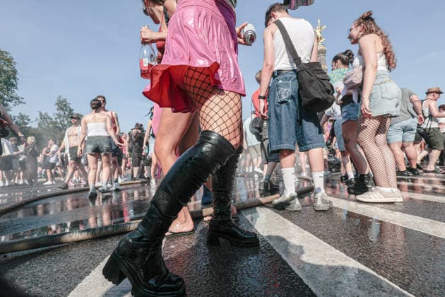 August 15, 2026, Berlin, Germany: A woman walks past hoses spraying cold water, placed by police to cool the crowd during the Rave the Planet techno parade. The event took place during a heatwave, with temperatures reaching 31 degrees Celsius. Berlin Germany - ZUMAs197 20260815_aab_s197_025 Copyright: xVasilyxKrestyaninovx