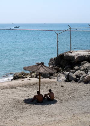 (260815) -- CEUTA, Aug. 15, 2026 -- Men watch Moroccan police patrol near the Tarajal border crossing in Ceuta, Spain, Aug. 15, 2026. More than 72,000 migrants crossed irregularly into Ceuta from neighboring Morocco on July 30 and 31, according to the Spanish government. Most returned to Morocco later, while thousands remain in the enclave.Security was also tightened along the border ahead of Saturday after calls for another mass crossing circulated on social media. Moroccan security forces intercepted hundreds of migrants attempting to reach the border area, while Ceuta reported no influx on a scale comparable to that seen in late July. ) SPAIN-CEUTA-VIEW MengxDingbo 