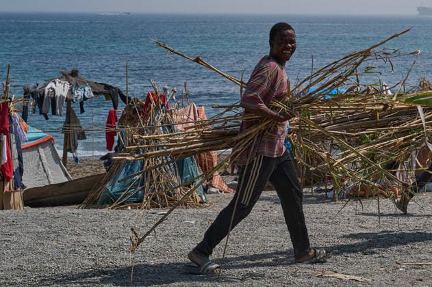 (260815) -- CEUTA, Aug. 15, 2026 -- An irregular migrant carries reeds to build a makeshift shelter in Ceuta, Spain, Aug. 15, 2026. More than 72,000 migrants crossed irregularly into Ceuta from neighboring Morocco on July 30 and 31, according to the Spanish government. Most returned to Morocco later, while thousands remain in the enclave.Security was also tightened along the border ahead of Saturday after calls for another mass crossing circulated on social media. Moroccan security forces intercepted hundreds of migrants attempting to reach the border area, while Ceuta reported no influx on a scale comparable to that seen in late July. ) SPAIN-CEUTA-VIEW MengxDingbo 