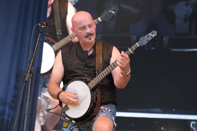 August 15, 2026, Williamscot, Oxfordshire, United Kingdom: Richard Collins, English banjo player with American rockgrass band Hayseed Dixie, performing live on stage at Fairport s Cropredy Convention. Formed in Nashville, Tennessee, in 2000,Hayseed Dixie is an American band that quoined the term rockgrass, which is hard rock and heavy metal songs played on traditional bluegrass instruments with. Their name is a parody of heavy metal band AC DC. The band consists of John Wheeler Barley Scotch on vocals, guitars, fiddle, keyboards, Hippy Joe Hymas on mandolin, acoustic guitar, vocals Jake Byers on bass, vocals Richard Collins on Banjo and vocals. Williamscot United Kingdom - ZUMAs197 20260815_aaa_s197_191 Copyright: xDawnxFletcher-Parkx