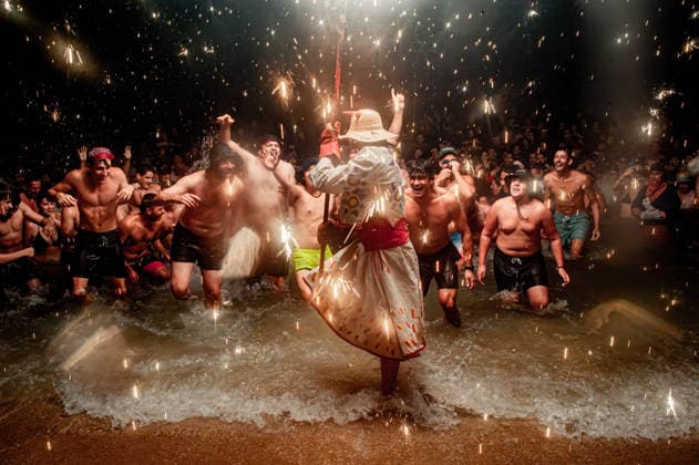 August 15, 2026, Badalona, Spain: People react as a Correfoc devil enters the sea during the August Festival in Badalona, north of Barcelona. The Correfoc, a traditional Catalan celebration featuring fireworks and fire-spitting performers, ends in the waters of Badalona beach. Badalona Spain  - ZUMAb137 20260815_fap_b137_007 Copyright: xJordixBoixareux