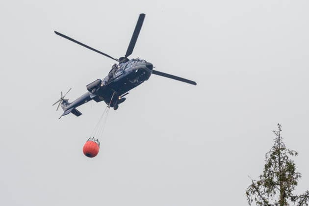 Hubschrauber der Bundeswehr im Einsatz beim Grossbrand im Wald von Huertgewald (Hürtgenwald) im Kreis Dueren (Düren) (Foto vom 15.08.2026). Der Grossbrand in der Gemeinde in Huertgenwald hat sich in der Nacht zu Samstag nicht weiter ausgebreitet. 1.400 Einsatzkraefte sind im Einsatz. Der Brand war am Donnerstagabend in der Eifelgemeinde ausgebrochen und hatte sich am Freitag auf etwa 300 Hektar ausgebreitet, eine Flaeche fast so gross wie der Central Park in New York. Es ist der groesste jemals dokumentierte Waldbrand in Nordrhein-Westfalen. (Siehe epd-Bericht vom 15.08.2026) EDITORIAL USE ONLY *** German Armed Forces helicopters in action during the major forest fire in Huertgenwald, in the district of Düren. Photo taken on August 15, 20 Copyright: epd-bild GuidoxSchiefer epd-Grossbrand_Huertgenwald6-kopieren