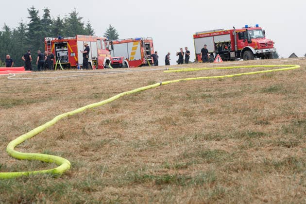 Feuerwehreinsatz in Gebieten des Waldbrandes in Huertgewald (Hürtgenwald) im Kreis Dueren (Foto vom 15.08.2026). Der Grossbrand in der Gemeinde in Huertgenwald hat sich in der Nacht zu Samstag nicht weiter ausgebreitet. 1.400 Einsatzkraefte sind im Einsatz. Der Brand war am Donnerstagabend in der Eifelgemeinde ausgebrochen und hatte sich am Freitag auf etwa 300 Hektar ausgebreitet, eine Flaeche fast so gross wie der Central Park in New York. Es ist der groesste jemals dokumentierte Waldbrand in Nordrhein-Westfalen. (Siehe epd-Bericht vom 15.08.2026) EDITORIAL USE ONLY *** Firefighting operation in areas affected by the wildfire in Hürtgenwald, Düren District. Photo taken on August 15, 2026. The major wildfire in the municipality of Hürtgen Copyright: epd-bild GuidoxSchiefer 260815_Waldbrand_H__rtgenwald_08