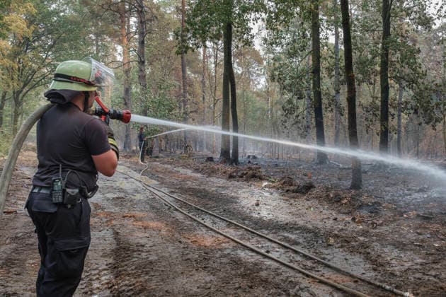 Loescharbeiten der Feuerwehr in Gebieten des Waldbrandes in Huertgewald (Hürtgenwald) im Kreis Dueren (Düren) (Foto vom 15.08.2026). Der Grossbrand in der Gemeinde in Huertgenwald hat sich in der Nacht zu Samstag nicht weiter ausgebreitet. 1.400 Einsatzkraefte sind im Einsatz. Der Brand war am Donnerstagabend in der Eifelgemeinde ausgebrochen und hatte sich am Freitag auf etwa 300 Hektar ausgebreitet, eine Flaeche fast so gross wie der Central Park in New York. Es ist der groesste jemals dokumentierte Waldbrand in Nordrhein-Westfalen. (Siehe epd-Bericht vom 15.08.2026) EDITORIAL USE ONLY *** Firefighters battling the wildfire in Huertgenwald, in the district of Düren. Photo taken on August 15, 2026. The major fire in the municipality of H Copyright: epd-bild GuidoxSchiefer 260815_Waldbrand_H__rtgenwald_19