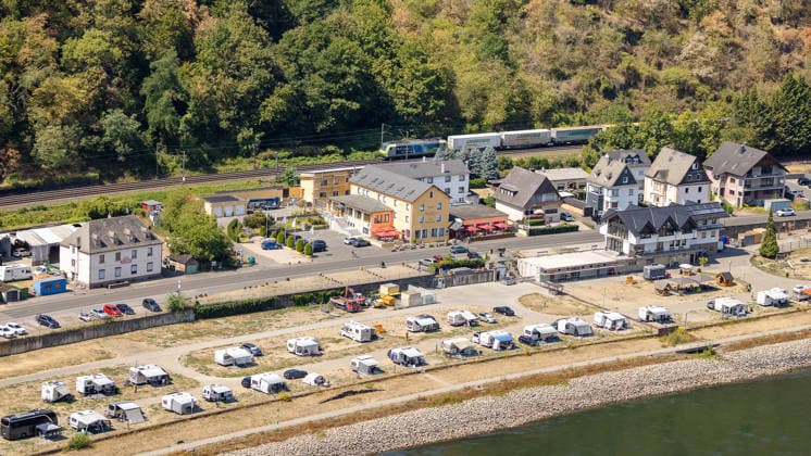 Niedrigwasser am Rhein nach langer Dürrephase, St. Goar, 15.08.2026 Ein Güterzug fährt auf der linken Rheinstrecke an einem Campingplatz mit zahlreichen Wohnwagen vorbei. Der Rhein führt sichtbares Niedrigwasser, breite Uferflächen liegen bei sommerlichem Wetter trocken. Sankt Goarshausen Rheinland-Pfalz Deutschland *** Low Water Levels on the Rhine Following a Long Drought, St. Goar, August 15, 2026 A freight train travels along the left bank of the Rhine, passing a campground with numerous RVs. The Rhine is visibly low, and wide stretches of the riverbank lie dry in the summer weather. Sankt Goarshausen, Rhineland-Palatinate, Germany 20260815-286A5809-M4000