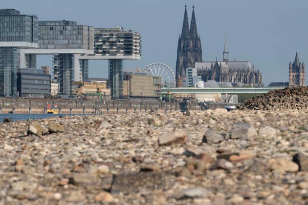 News Bilder des Tages Eine Teleaufnahme zeigt die markante Kölner Stadtkulisse mit den modernen Kranhäusern im Rheinauhafen und den gotischen Türmen des Kölner Doms im Hintergrund. Im unscharfen Vordergrund erstreckt sich das weitläufige, freigelegte Kiesel- und Steinufer des Rheins, das die Auswirkungen von extremem sommerlichem Niedrigwasser dokumentiert. *** A telephoto shot captures the prominent Cologne cityscape featuring the modern Kranhäuser buildings in the Rheinauhafen and the Gothic spires of the Cologne Cathedral in the background. In the blurred foreground, the vast, exposed pebble and stone bank of the Rhine illustrates the impact of extreme summer low water levels. Next to the cathedral, the white Nordrhein-Westfalen Deutschland, Germany 20260816-DSCF2154