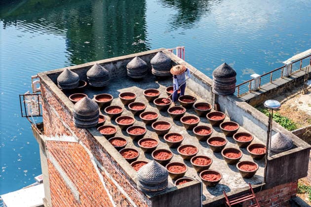 (260816) -- SHUANGFENG, Aug. 16, 2026 -- A resident airs chili sauce on a rooftop in Yongfeng Subdistrict of Shuangfeng County, Loudi City of central China s Hunan Province, Aug. 16, 2026. As one of China s protected geographical indication products, chili sauce made in Yongfeng Subdistrict boasts a history of several centuries. (Photo by Xinhua) CHINA-HUNAN-SHUANGFENG-CHILI SAUCE-PREPARATION (CN) LixJianxin 