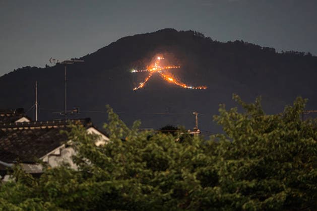 General view, August 16, 2026 - The Kyoto Gozan Okuribi or Five Mountain Bonfires, illuminate the night sky over Kyoto, Japan. The traditional summer observance marks the end of the Obon season, as five mountains surrounding the city are lit with bonfires to send ancestral spirits back to the afterlife.  aflo_341148126