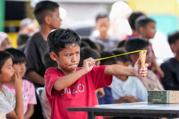 August 16, 2026, Banda Aceh, Aceh, Indonesia: A boy focuses on aiming at a target during a slingshot competition held to celebrate Indonesia s 81st Independence Day in Banda Aceh, Aceh Province, Indonesia, on Sunday. Residents organized various traditional competitions to foster a sense of togetherness and entertain the local community in celebration of Independence Day. Banda Aceh Indonesia - ZUMAi115 20260816_zip_i115_014 Copyright: xMuhammadxIqbalx