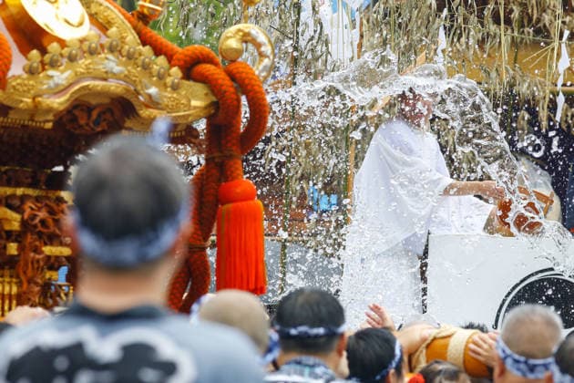 August 16, 2026, Tokyo, Japan: Shinto ritual attendant seen pouring purifying water from a traditional wooden bucket over shrine bearers during the Fukagawa Hachiman Festival. The triennial festival is one of Tokyo s top three major Edo-period festivals held at Tomioka Hachimangu Shrine. It is well known as the Water-Splashing Festival (Mizukake Matsuri), where participants toss gallons of purifying water onto shrine bearers to beat the intense midsummer heat and bless the local community. Tokyo Japan - ZUMAs197 20260816_aaa_s197_076 Copyright: xRodrigoxReyesxMarinx