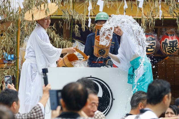 August 16, 2026, Tokyo, Japan: Shinto ritual attendants seen pouring purifying water from a traditional wooden buckets over shrine bearers during the Fukagawa Hachiman Festival. The triennial festival is one of Tokyo s top three major Edo-period festivals held at Tomioka Hachimangu Shrine. It is well known as the Water-Splashing Festival (Mizukake Matsuri), where participants toss gallons of purifying water onto shrine bearers to beat the intense midsummer heat and bless the local community. Tokyo Japan - ZUMAs197 20260816_aaa_s197_081 Copyright: xRodrigoxReyesxMarinx