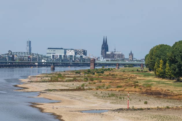 Historischer Niedrigwasser-Rekord am Rhein Blick von der Rodenkirchener Brücke auf Köln - 16.08.26 Blick von der Rheinbrücke Köln Rodenkirchen (A4) auf die Kölner Skyline bei historischem Niedrigwasser des Rheins. Das Flussbett liegt größtenteils frei. Der Pegel Köln erreicht einen Tiefstand von 46 cm und unterbietet damit den bisherigen Rekord von 69 cm aus dem Jahr 2018 deutlich. Die Rheinschifffahrt ist durch das extrem niedrige Wasser stark eingeschränkt. Im Hintergrund der Kölner Dom und die markanten Kranhäuser Köln Rodenkirchen Nordrhein-Westfalen Deutschland *** Record-Low Water Level on the Rhine: View of Cologne from the Rodenkirchen Bridge, August 16, 2026. View of the Cologne skyline from the Rhine Bridge at Rode Copyright: xMarcxJohnx