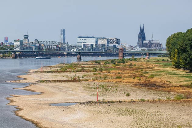 Historischer Niedrigwasser-Rekord am Rhein Blick von der Rodenkirchener Brücke auf Köln - 16.08.26 Blick von der Rheinbrücke Köln Rodenkirchen (A4) auf die Kölner Skyline bei historischem Niedrigwasser des Rheins. Das Flussbett liegt größtenteils frei. Der Pegel Köln erreicht einen Tiefstand von 46 cm und unterbietet damit den bisherigen Rekord von 69 cm aus dem Jahr 2018 deutlich. Die Rheinschifffahrt ist durch das extrem niedrige Wasser stark eingeschränkt. Im Hintergrund der Kölner Dom und die markanten Kranhäuser Köln Rodenkirchen Nordrhein-Westfalen Deutschland *** Record-Low Water Level on the Rhine: View of Cologne from the Rodenkirchen Bridge, August 16, 2026. View of the Cologne skyline from the Rhine Bridge at Rode Copyright: xMarcxJohnx