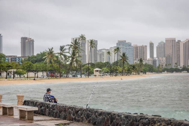 August 16, 2026, Honolulu, Hawaii, U.S: A fisherman tries his luck at Point Panic in Honolulu after Hurricane Lala struck Hawaii in the early morning hours of Sunday, August 16, 2026. Ala Moana Beach in the background is a popular location for tourists who typically flock to the beach in the hundreds, but widespread flooding and power outages plagued the area following the high winds and rain brought by the hurricane. Honolulu U.S  - ZUMAd149 20260816_zap_d149_005 Copyright: xJamesxD.xDeCampx