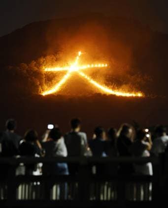 Mountain bonfire in Kyoto A giant bonfire forming the Chinese character for large is lit on a mountainside in Kyoto during the Gozan Okuribi event, a traditional ceremony held to send off ancestral spirits and pray for good health, on Aug. 16. 2026.  A14AA0005625924P