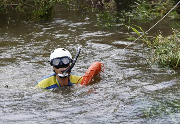 Aftermath of torrential rain in Chiba A police officer searches for missing persons in a swollen river in Chiba near Tokyo on Aug. 15, 2026, following the torrential rain that hit the region on Aug. 13.  A14AA0005626012P