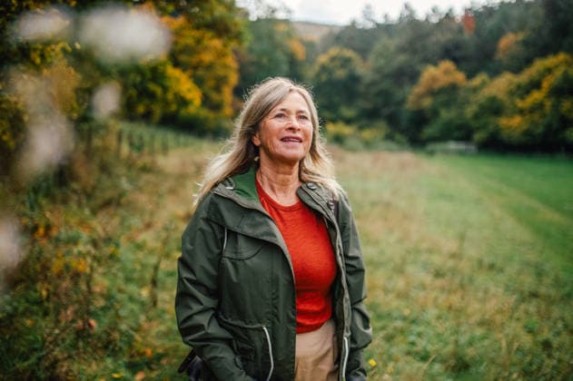 Happy senior woman on nature walk during rainy autumn day. Happy senior woman on nature walk during rainy autumn day. Fall hygge moment. model released