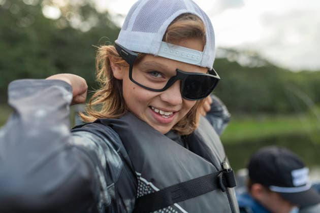Smiling boy in sunglasses flexing on a boat Seminole, Oklahoma, United States CR_AOVS260816A-2090264-01 ,model released, Symbolfoto ,property released