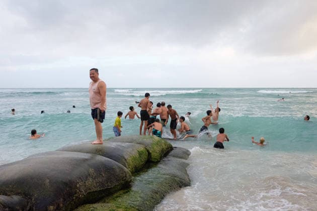 August 16, 2026, Honolulu, Hawaii, USA: Tropical storm LalaÃ¢â‚¬â ¢s worst affected Oahu and Waikiki beginning after 1:00 a.m. Sunday August 16, 2026 and lasted, tapering, through mid-afternoon leaving behind flooding, downed trees, and more than 130,000 Hawaiian Electric customers without power at 4:00 p.m. But at sunset Waikiki Beach was packed with people taking advantage of a brief respite from the rain that the National Weather Service forecasts will last through the week as the slow-moving storm moves Northwest beneath the Hawaiian archipelago. Schools, government offices and many businesses will remain closed on Monday as people on OÃ¢â‚¬Ëœahu sort through the stormÃ¢â‚¬â ¢s consequences. Kids play on a burrito erosion prevention  - ZUMAm255 20260816_znp_m255_002 Copyright: xJ.xMattx