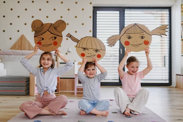 Children exploring feelings and facial expressions through creative play. Girls developing emotional awareness through educational play. model released