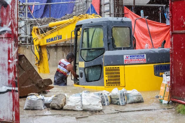 (260817) -- QUEZON CITY, Aug. 17, 2026 -- A man checks an excavator submerged in floodwater in Quezon City, the Philippines, on Aug. 17, 2026. The Philippine government has suspended in-person classes in Metro Manila and 12 other provinces as heavy rains from tropical cyclones and the southwest monsoon continue to batter the country, local media reported on Monday. The extreme rainfall has triggered severe flooding and landslides across the nation. The well-known flood-control corruption scandal has left key infrastructure unfinished or poorly maintained, further straining the country s disaster response, local media reported. ) THE PHILIPPINES-QUEZON CITY-SOUTHWEST MONSOON-FLOOD RouellexUmali 