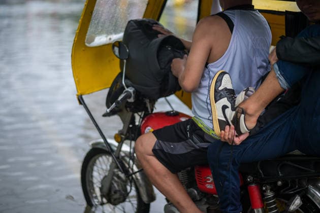 August 17, 2026, Philippines: Commuter taking off his flood water-soaked shoes at Quirino Ave., Manila, Metro Manila. Two days ago, Metro Manila and neighboring provinces experienced a hot and humid weather. Monsoon rain came back yesterday and persisted throughout the day with flash floods in different areas of the metropolitan. Philippines - ZUMAr240 20260817_zip_r240_046 Copyright: xMarcxDominicxRostratax