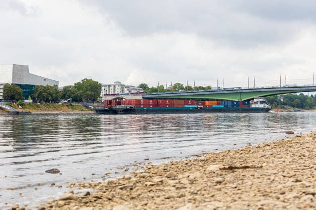 Binnenschiff fährt bei Niedrigwasser auf dem Rhein in Bonn Bonn, 17. August 2026: Ein mit Containern beladenes Binnenschiff fährt bei deutlich niedrigem Wasserstand auf dem Rhein in Bonn. Der Rhein führt derzeit aufgrund anhaltender Trockenheit und geringer Niederschläge außergewöhnlich wenig Wasser. Am Pegel Bonn wurde am 17. August ein Wasserstand von rund 62 bis 64 Zentimetern gemessen. Der für Bonn angegebene Gleichwertige Wasserstand (GlW) liegt bei 142 Zentimetern. Das Niedrigwasser erschwert die Binnenschifffahrt und kann dazu führen, dass Schiffe ihre Ladung reduzieren müssen. Bonn Beuel Nordrhein-Westfalen Deutschland *** Inland waterway vessel navigates the Rhine in Bonn during low water levels Bonn, August 17, 2026 A bar