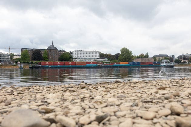 Binnenschiff fährt bei Niedrigwasser auf dem Rhein in Bonn Bonn, 17. August 2026: Ein mit Containern beladenes Binnenschiff fährt bei deutlich niedrigem Wasserstand auf dem Rhein in Bonn. Der Rhein führt derzeit aufgrund anhaltender Trockenheit und geringer Niederschläge außergewöhnlich wenig Wasser. Am Pegel Bonn wurde am 17. August ein Wasserstand von rund 62 bis 64 Zentimetern gemessen. Der für Bonn angegebene Gleichwertige Wasserstand (GlW) liegt bei 142 Zentimetern. Das Niedrigwasser erschwert die Binnenschifffahrt und kann dazu führen, dass Schiffe ihre Ladung reduzieren müssen. Bonn Beuel Nordrhein-Westfalen Deutschland *** Inland waterway vessel navigates the Rhine in Bonn during low water levels Bonn, August 17, 2026 A bar