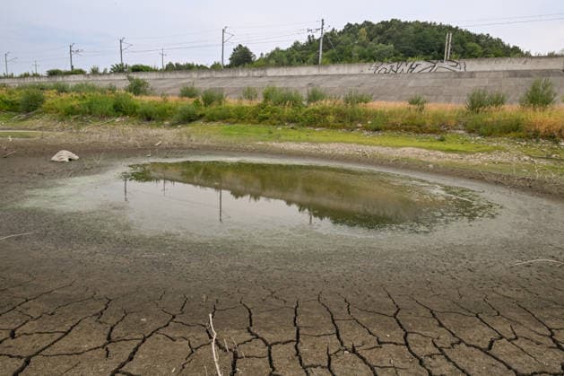 Historic summer heatwave drains southern Poland waterways ZEMBRZYCE, POLAND - AUGUST 17: A small, stagnant pool of green water sits isolated amidst a vast expanse of deeply fractured, cracked earth in the dried-up basin of the Skawa River in Zembrzyce, southern Poland, on August 17, 2026. A record-breaking summer heatwave and acute lack of rainfall have caused water levels to plummet by over a meter, cutting off natural flows and stranding water pockets below a concrete railway embankment. The severe hydrological drought has forced regional authorities to enforce emergency water restrictions across the Malopolska province. Artur Widak Anadolu Zembrzyce Poland. Editorial use only. Please get in touch for any other usage.  Copyright: x2026xAnadoluxArturxWidakx