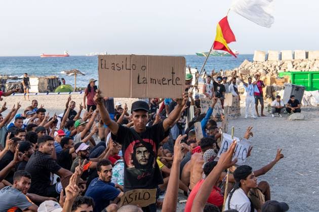 August 17, 2026, Ceuta, Spain: CEUTA, SPAIN Ã¢â‚¬ AUGUST 17, 2026: More than 100 migrants, most of them Moroccan, have been protesting for days in front of National Police vans during the daily food distribution provided by the Spanish Red Cross at TrampoloÂ­n Beach. Ã¢â‚¬oeNo asylum, no foodÃ¢â‚¬Â is the chant repeated by the migrants on the sand, while African migrants continue to stay in the temporary accommodation facilities set up on the Ceuta beach. Authorities are expected to clear the beach in the coming days and transfer the migrants to four reception facilities announced today by SpainÃ¢â‚¬â ¢s Minister for Migration, Elma Saiz. Ceuta Spain - ZUMAq101 20260817_zna_q101_078 Copyright: xAntonioxSemperex