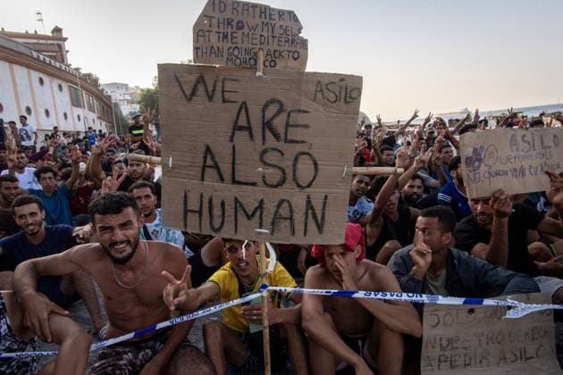 August 17, 2026, Ceuta, Spain: CEUTA, SPAIN Ã¢â‚¬ AUGUST 17, 2026: More than 100 migrants, most of them Moroccan, have been protesting for days in front of National Police vans during the daily food distribution provided by the Spanish Red Cross at TrampoloÂ­n Beach. Ã¢â‚¬oeNo asylum, no foodÃ¢â‚¬Â is the chant repeated by the migrants on the sand, while African migrants continue to stay in the temporary accommodation facilities set up on the Ceuta beach. Authorities are expected to clear the beach in the coming days and transfer the migrants to four reception facilities announced today by SpainÃ¢â‚¬â ¢s Minister for Migration, Elma Saiz. Ceuta Spain  - ZUMAq101 20260817_zna_q101_080 Copyright: xAntonioxSemperex
