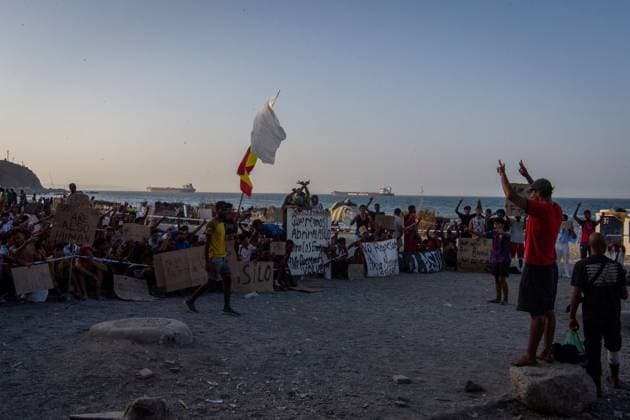 August 17, 2026, Ceuta, Spain: CEUTA, SPAIN Ã¢â‚¬ AUGUST 17, 2026: More than 100 migrants, most of them Moroccan, have been protesting for days in front of National Police vans during the daily food distribution provided by the Spanish Red Cross at TrampoloÂ­n Beach. Ã¢â‚¬oeNo asylum, no foodÃ¢â‚¬Â is the chant repeated by the migrants on the sand, while African migrants continue to stay in the temporary accommodation facilities set up on the Ceuta beach. Authorities are expected to clear the beach in the coming days and transfer the migrants to four reception facilities announced today by SpainÃ¢â‚¬â ¢s Minister for Migration, Elma Saiz. Ceuta Spain - ZUMAq101 20260817_zna_q101_082 Copyright: xAntonioxSemperex