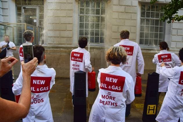 Anti-Rosebank Protests in London, UK - 17 Aug 2026 Climate activists from the group Scientists On Survival wearing lab coats spray the building with water using fire extinguishers during a protest against Rosebank outside the Department for Energy Security and Net Zero (DESNZ). Two separate groups staged protests in Westminster as the public consultation on the North Sea oil and gas field concludes. London United Kingdom Copyright: xVukxValcicx xSOPAxImagesx Vuk-Valcic-1442820