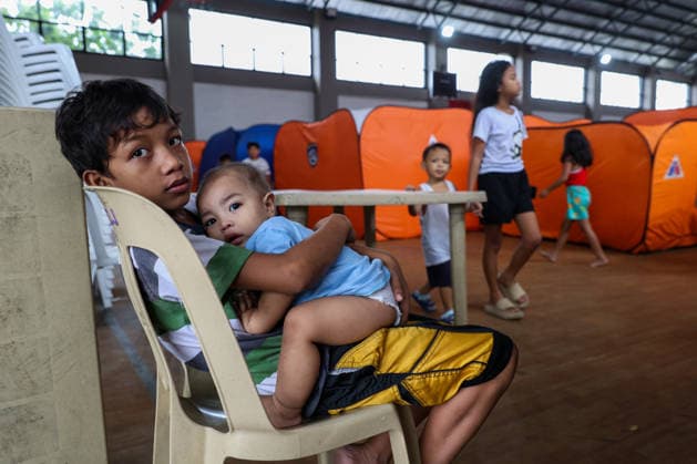 Tens of thousands evacuated in Philippines amid monsoon rains, floods QUEZON CITY, PHILIPPINES: A boy and his little brother evacuated from flooded areas take shelter at a secondary school basketball court, amid lingering threats of flooding caused by heavy monsoon rains, in Quezon City, Metro Manila, Philippines, on August 18, 2026. As the country remains threatened by floods caused by monsoon heavy rains, tens of thousands of people in the capital region of Metro Manila and its surrounding cities and areas have been evacuated, with schools in multiple locations across the Philippines being suspended for safety reasons. Daniel Ceng Anadolu Quezon City Philippines. Editorial use only. Please get in touch for any other usage.  Copyright: x2026xAnadoluxDanielxCengx