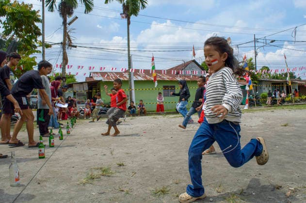 Indonesia s 81st Independence Day Festive Determination - Medan Children participate in the Lomba Balap Kelereng (marble race) to celebrate Indonesian Independence Day on August 17, 2026. One girl balances a marble on a spoon in her mouth, hands behind her back, focusing on not dropping it. In the background, other children race while residents of Neighborhood IV in Karang Sari village, Medan Polonia, North Sumatra, watch the event. Photo by Aditya Sutanta ABACAPRESS.COM Medan Indonesia  Copyright: xAdityaxSutanta ABACAx