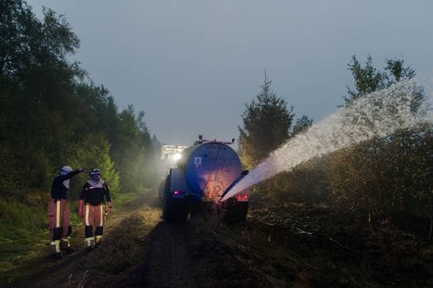 Farmers use their equipment to assist firefighters, as a fire rages in the Hautes Fagnes (High Fens) nature reserve, on Tuesday 18 August 2026. The fire started on August 14th and 2700 hectares (on a total of 4500) are impacted.  NICOLASxLAMBERT 183633869