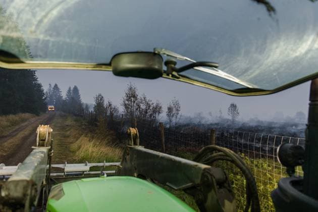 Farmers use their equipment to assist firefighters, as a fire rages in the Hautes Fagnes (High Fens) nature reserve, on Tuesday 18 August 2026. The fire started on August 14th and 2700 hectares (on a total of 4500) are impacted.  NICOLASxLAMBERT 183633879