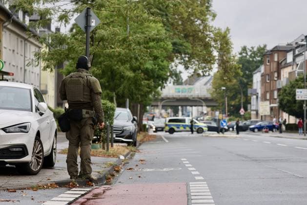 Police seal off Erlenhofstrasse in Cologne after reports of gunshots from attic COLOGNE, GERMANY - AUGUST 18: German police officers secure the cordoned-off perimeter around Erlenhofstrasse during an ongoing armed operation in the Niehl district of Cologne, Germany, on August 18, 2026. Following reports that a man fired gunshots into the air from an attic apartment, numerous police units were dispatched to the scene, shutting down Erlenhofstrasse and surrounding connecting roads to vehicular and pedestrian traffic while urging the public to avoid the area. Kadir Ilboga Anadolu Cologne Germany. Editorial use only. Please get in touch for any other usage.  Copyright: x2026xAnadoluxKadirxIlbogax