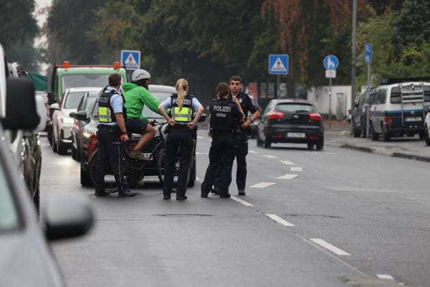 Police seal off Erlenhofstrasse in Cologne after reports of gunshots from attic COLOGNE, GERMANY - AUGUST 18: German police officers secure the cordoned-off perimeter around Erlenhofstrasse during an ongoing armed operation in the Niehl district of Cologne, Germany, on August 18, 2026. Following reports that a man fired gunshots into the air from an attic apartment, numerous police units were dispatched to the scene, shutting down Erlenhofstrasse and surrounding connecting roads to vehicular and pedestrian traffic while urging the public to avoid the area. Kadir Ilboga Anadolu Cologne Germany. Editorial use only. Please get in touch for any other usage.  Copyright: x2026xAnadoluxKadirxIlbogax