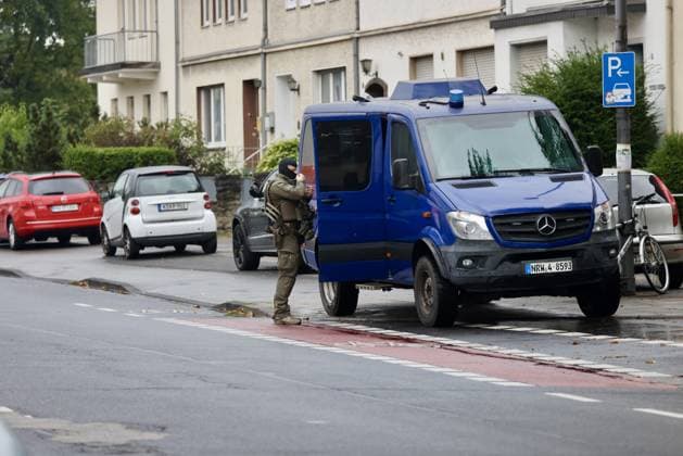 Police seal off Erlenhofstrasse in Cologne after reports of gunshots from attic COLOGNE, GERMANY - AUGUST 18: German police officers secure the cordoned-off perimeter around Erlenhofstrasse during an ongoing armed operation in the Niehl district of Cologne, Germany, on August 18, 2026. Following reports that a man fired gunshots into the air from an attic apartment, numerous police units were dispatched to the scene, shutting down Erlenhofstrasse and surrounding connecting roads to vehicular and pedestrian traffic while urging the public to avoid the area. Kadir Ilboga Anadolu Cologne Germany. Editorial use only. Please get in touch for any other usage.  Copyright: x2026xAnadoluxKadirxIlbogax