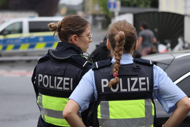 Police seal off Erlenhofstrasse in Cologne after reports of gunshots from attic COLOGNE, GERMANY - AUGUST 18: German police officers secure the cordoned-off perimeter around Erlenhofstrasse during an ongoing armed operation in the Niehl district of Cologne, Germany, on August 18, 2026. Following reports that a man fired gunshots into the air from an attic apartment, numerous police units were dispatched to the scene, shutting down Erlenhofstrasse and surrounding connecting roads to vehicular and pedestrian traffic while urging the public to avoid the area. Kadir Ilboga Anadolu Cologne Germany. Editorial use only. Please get in touch for any other usage.  Copyright: x2026xAnadoluxKadirxIlbogax